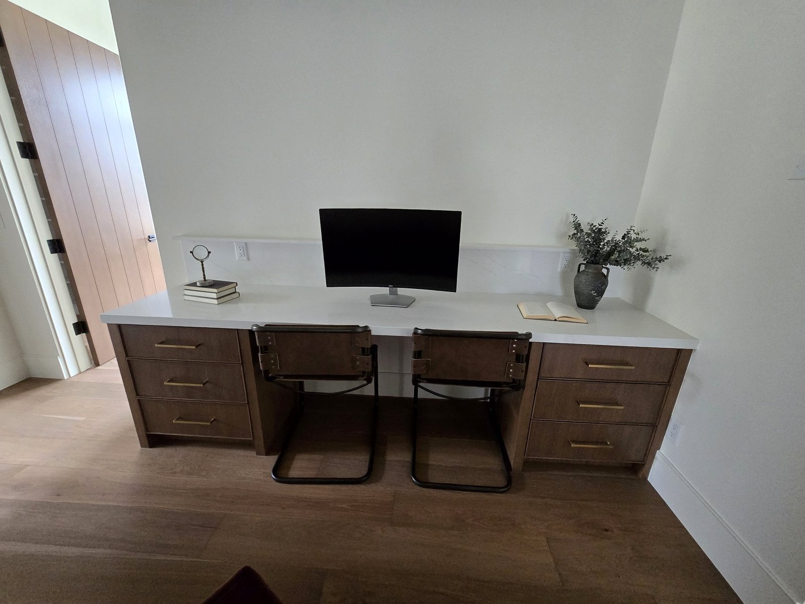 Custom home office desk built-ins with dark wood drawers and stone top