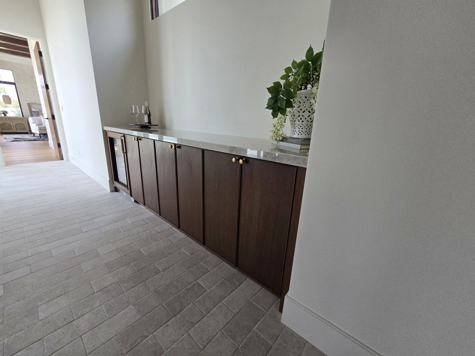 Hallway base cabinet installation with stone top and dark wood cabinet fronts